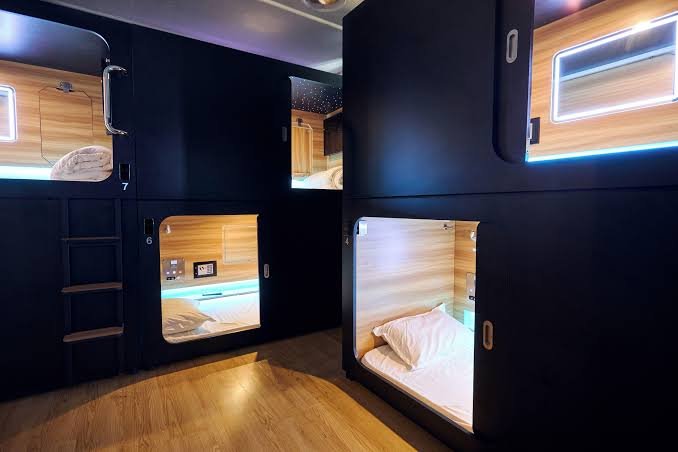 A row of identical compact sleeping units along a plain corridor.