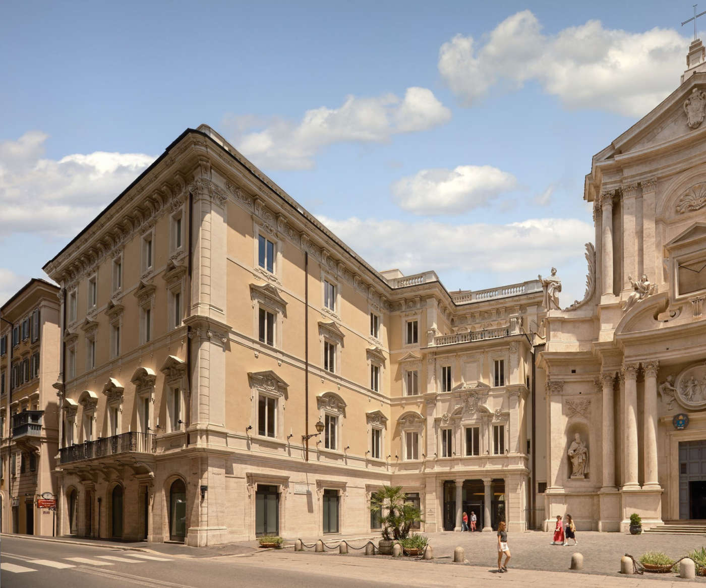 A stone courtyard inside an old Roman palace building with arched openings on two sides.